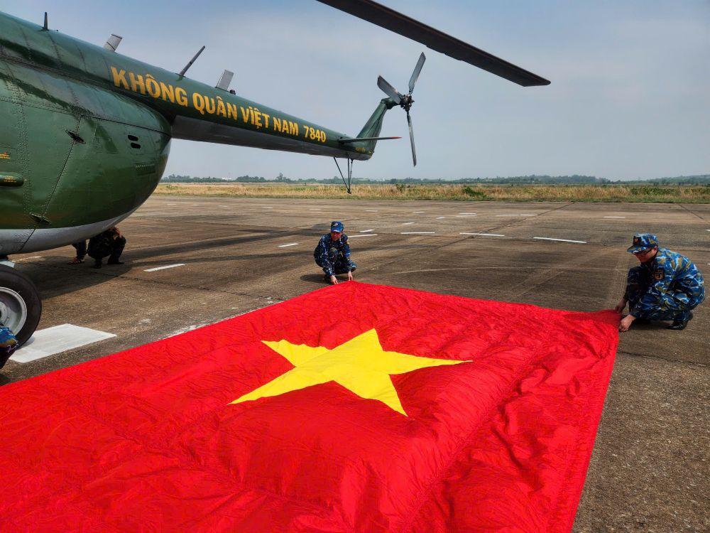 Các chiến sĩ đang xếp cờ chuẩn bị treo lên trực thăng để diễn tập. Ảnh: Anh Tú