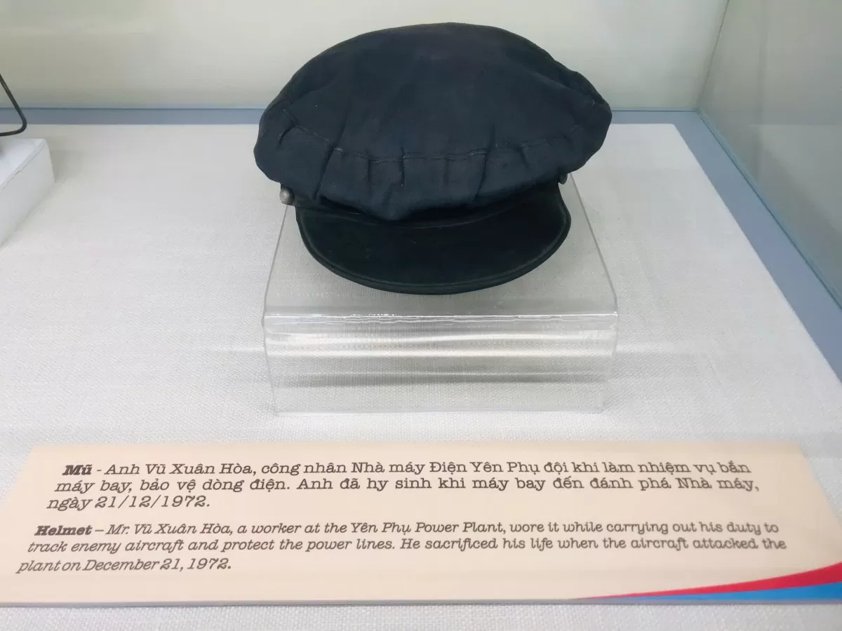 Mũ - Anh Vũ Xuân Hoà công nhân nhà máy Điện Yên Phụ đội khi làm nhiệm vụ bắn máy bay bảo vệ dòng điện. Anh đã hy sinh khi máy bay đánh phá Nhà máy ngày 21/12/1972