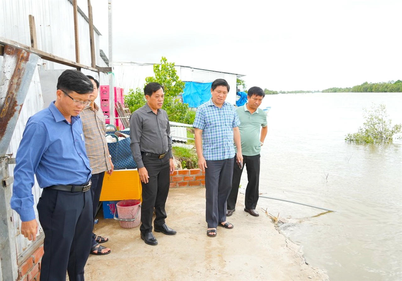 Ông Lê Văn Sử - Phó Chủ tịch UBND tỉnh Cà Mau (thứ hai từ phải sang) kiểm tra tình hình sạt lở tại khu vực nhà dân ở ấp Chòi Mòi, xã Định Thành.