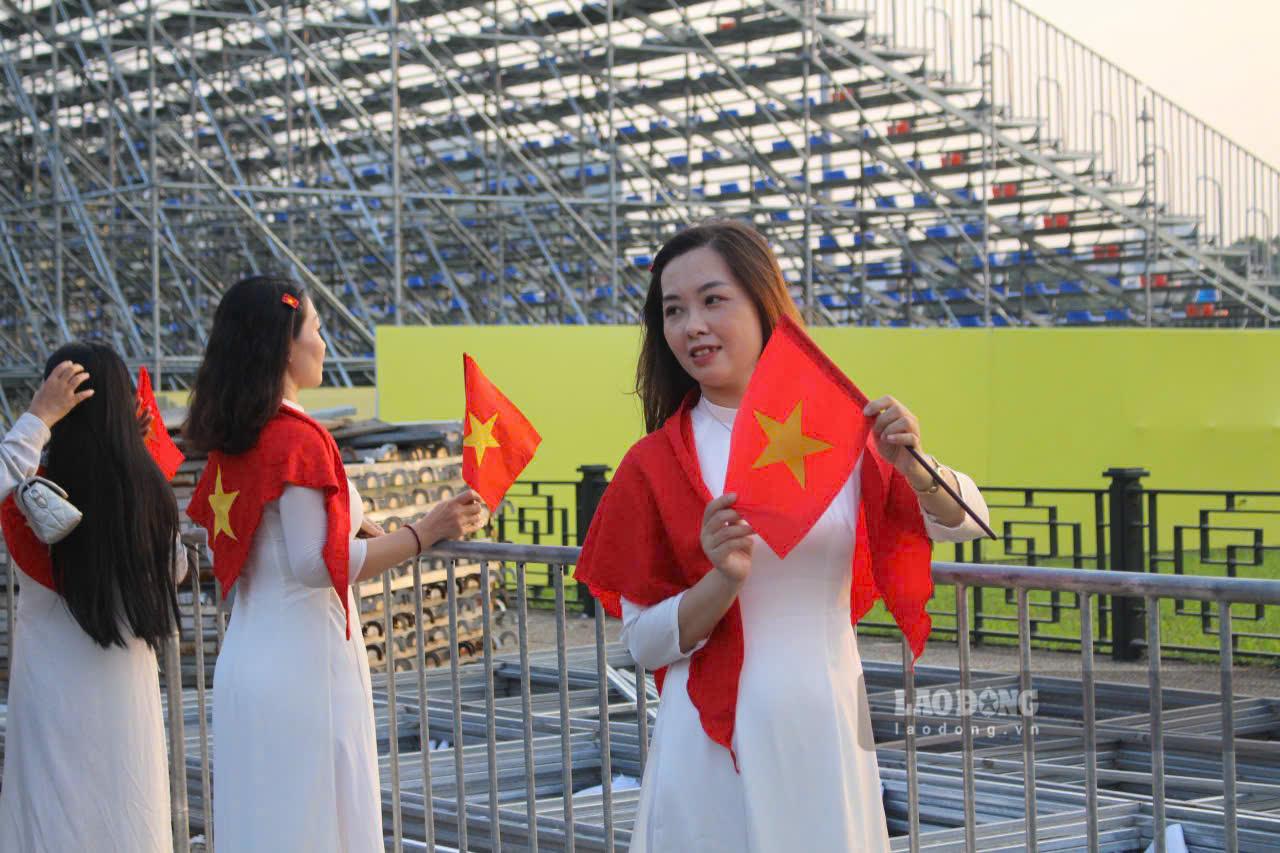 Phần lớn các thiếu nữ đều lựa chọn trang phục đơn giản với áo dài trắng, mang theo nón lá, cờ Tổ quốc, hoặc hoa sen để chụp ảnh trước quảng trường Ba Đình.