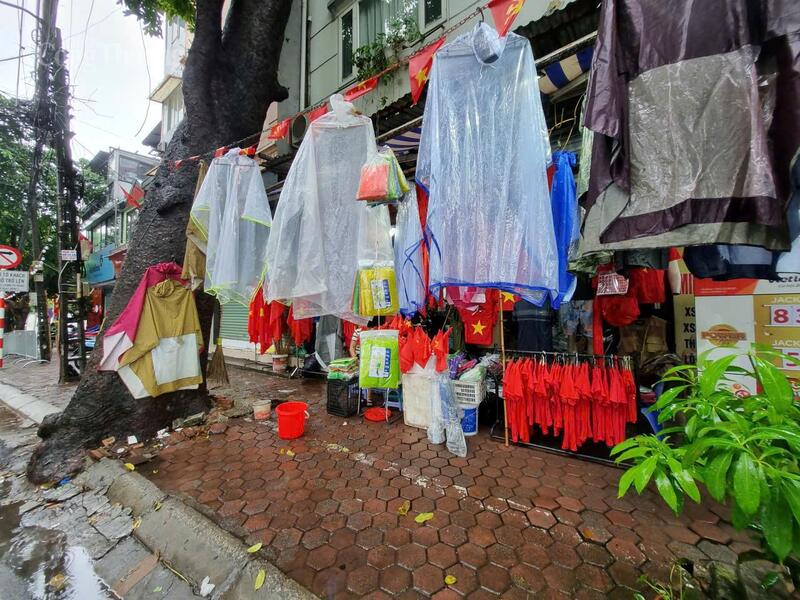 Ngoài cờ hoa, những gian hàng trên phố Hoàng Hoa Thám, Thụy Khuê, Điện Biên Phủ còn treo bán các loại áo mưa nhiều màu sắc, từ loại mỏng 10.000 đồng, áo bộ vài chục nghìn đồng đến cả trăm nghìn đồng.