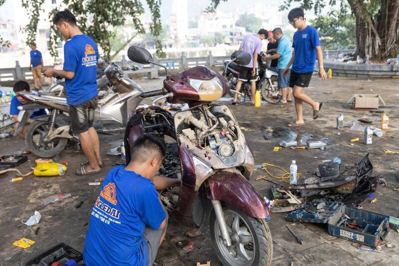 Hỗ trợ người dân sửa xe máy miễn phí sau mưa lũ. Ảnh: Vũ Mừng
