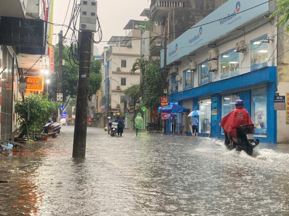 Chở hàng lên đến nơi, anh Hiền ngán ngẩm vì nước ngập không phân biệt lòng đường, vỉa hè. Ảnh: Quỳnh Chi