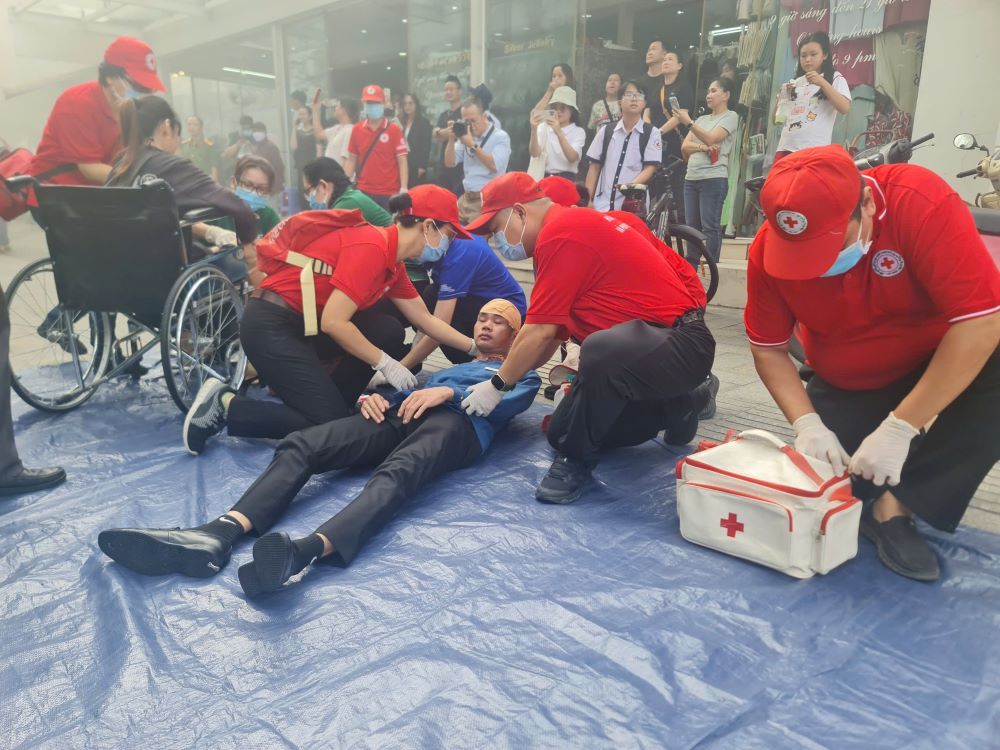 Nhân viên y tế sơ cứu “nạn nhân” được đưa ra khỏi khu vực cháy trong buổi diễn tập. Ảnh: Thanh Tàu