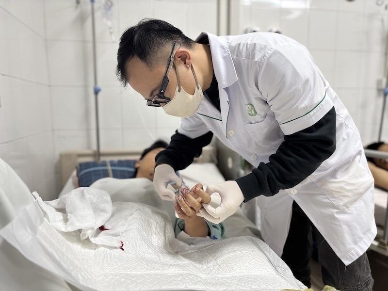 Bác sĩ thăm khám cho một bệnh nhân bị dập nát bàn tay do pháo nổ. Ảnh: BVCC