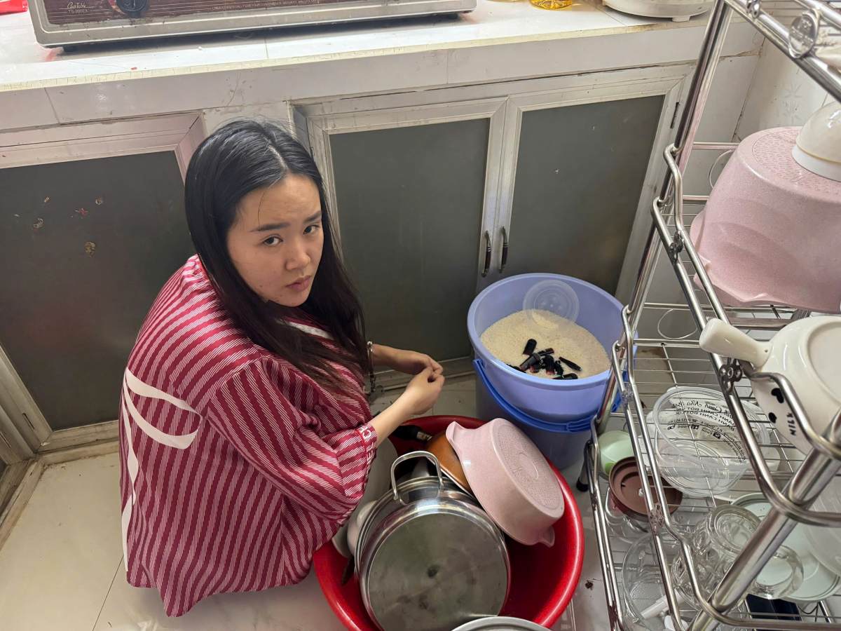 Đối tượng Huỳnh Ngọc Thuý Như và tang vật là các đầu đốt tinh dầu chứa ma tuý etomidate được giấu trong thùng gạo. Ảnh: Công an