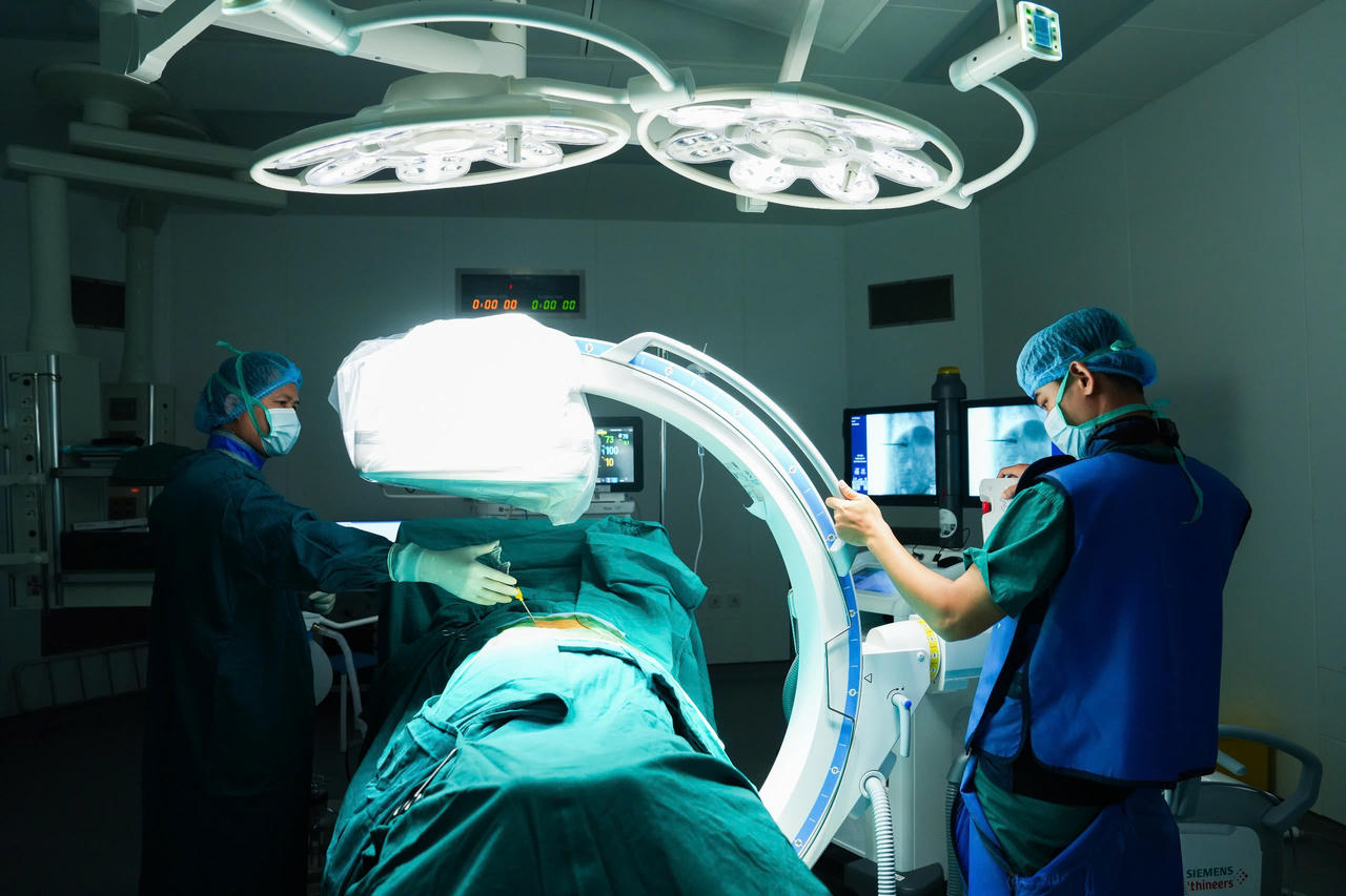 Các bác sĩ Bạch Mai tạo hình thân đốt sống bằng bơm xi măng sinh học có bóng (Balloon Kyphoplasty) cho bệnh nhân tại cơ sở Ninh Bình. Ảnh: Thành Dương.