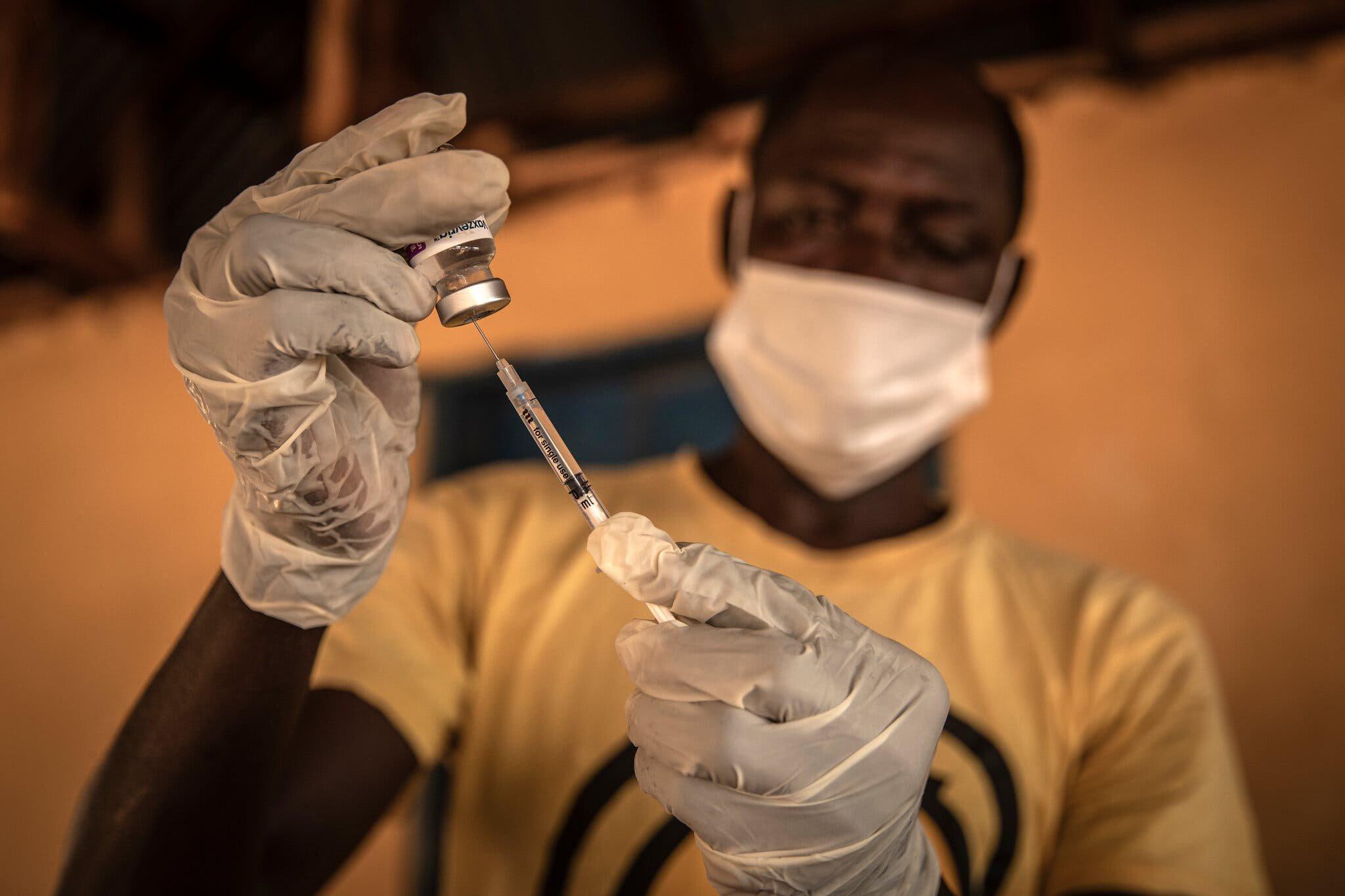 Nhân viên y tế ở thị trấn Kathantha Yimbo, Sierra Leone chuẩn bị vaccine Covid-19. Ảnh: Finbarr O'Reilly/The New York Times.