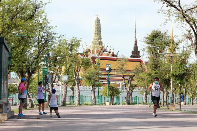 Người dân Bangkok đeo khẩu trang phòng Covid-19 khi tập thể dục - Ảnh: Apichart Jinakul