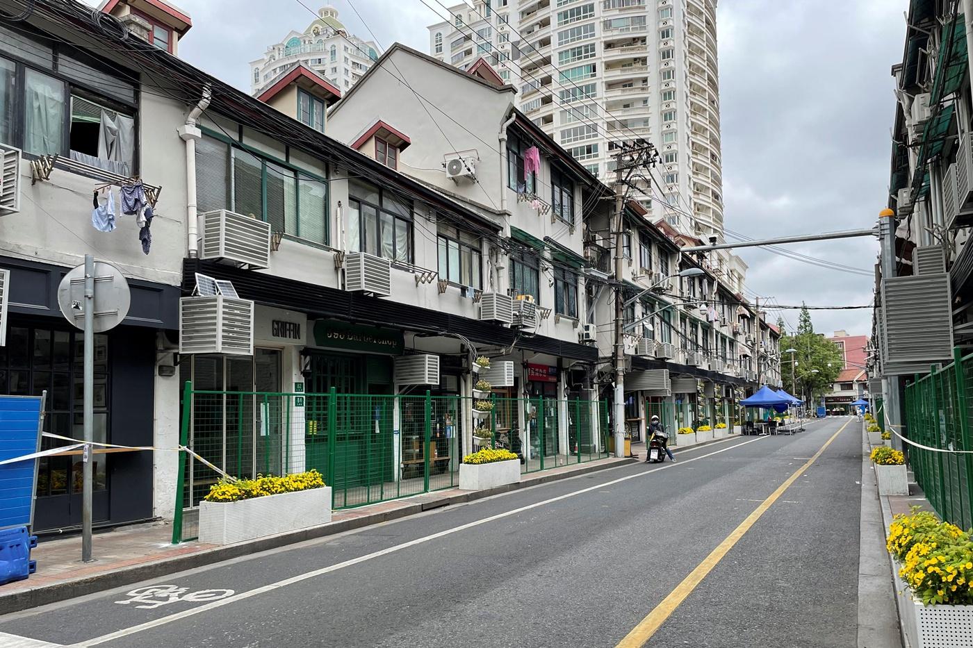 Hàng rào xanh phong tỏa lối vào các cửa hàng và khu dân dọc một con phố tại Thượng Hải hôm 24/4. Ảnh: Reuters.