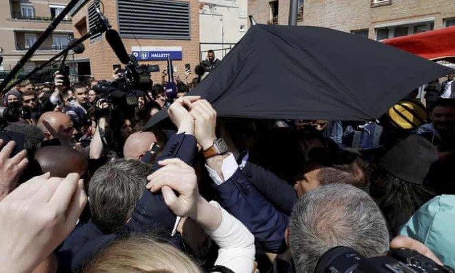 Các vệ sĩ bảo vệ ông Emmanuel Macron sau khi ông suýt bị ném cà chua vào người. Ảnh: AP.
