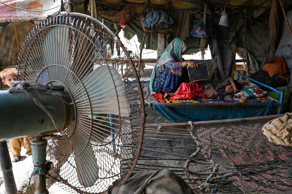 Người mẹ dùng giấy quạt cho con giữa lúc Jacobabad bị cắt điện hôm 11/5. Ảnh: AFP.