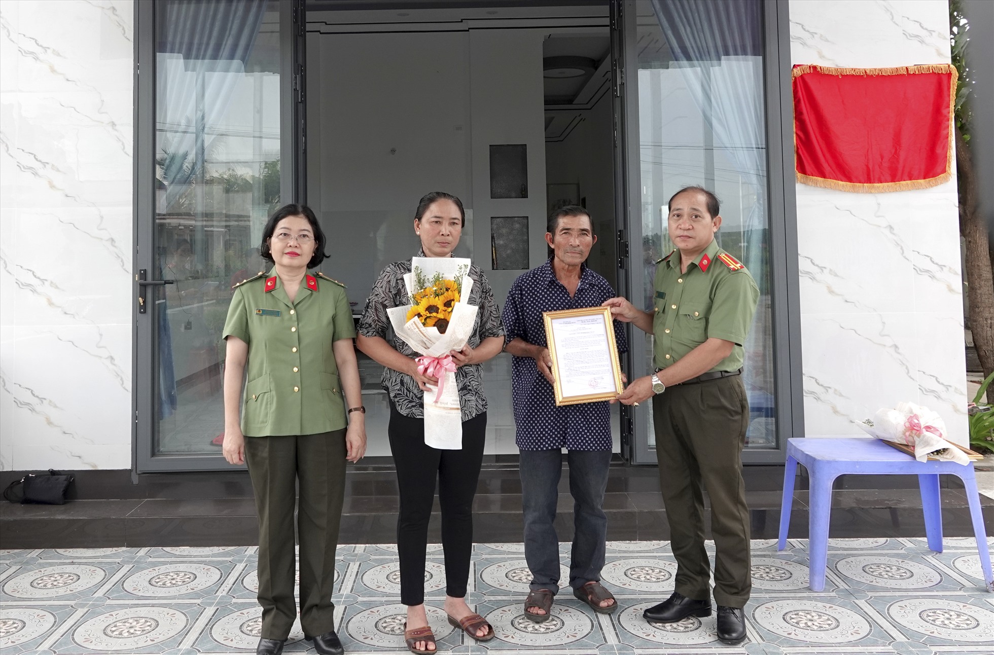 Trung tá Đặng Ái Ly,Trưởng phòng Công tác đảng và công tác chính trị trao quyết định tặng nhà. Ảnh: Như Ý