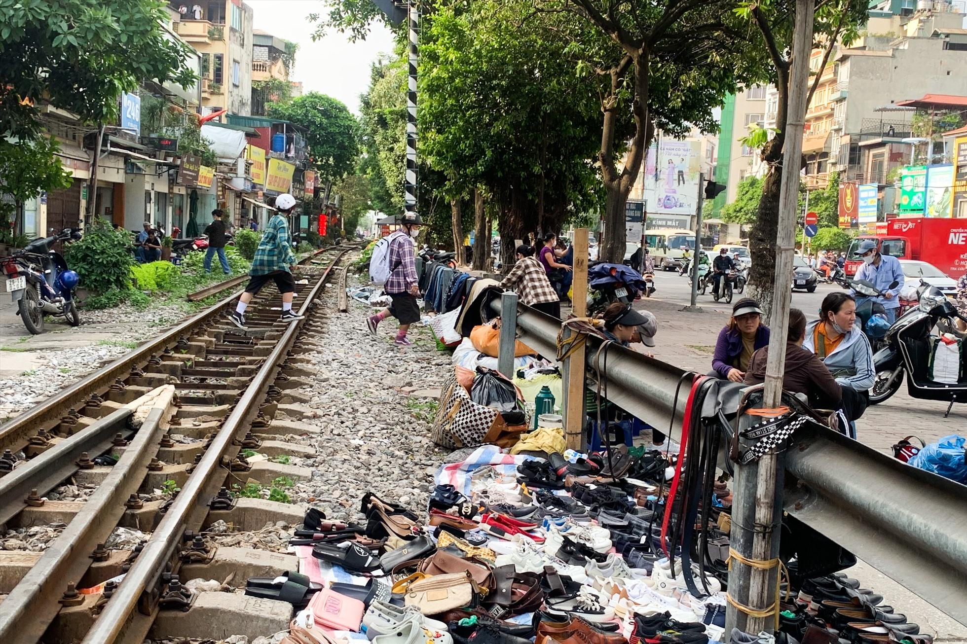 Người dân vô tư băng qua đường sắt để mua hàng. Ảnh: Thu Hiền