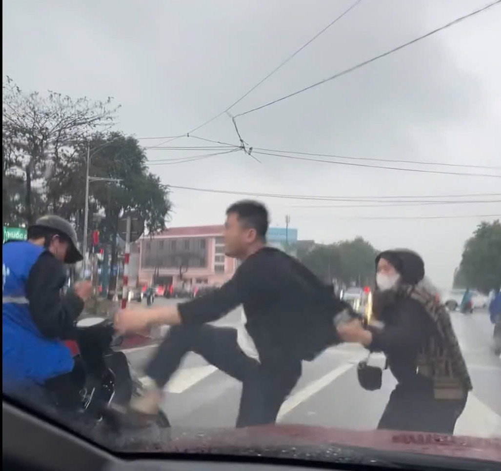 Mặc dù có người can ngăn, nhưng người đàn ông vẫn đánh đập, hành hung thiếu niên đi xe máy. Ảnh cắt từ clip