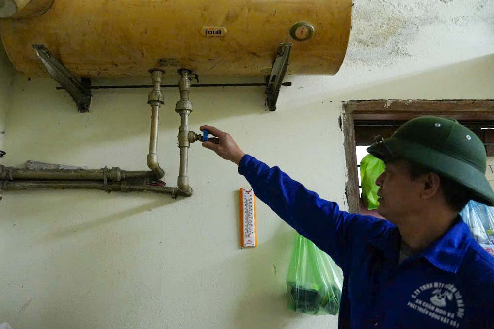 Nhân viên vườn thú vận hành bình đun nước nóng để cấp nước ấm vào bể cho hà mã. Ảnh: Hữu Vũ