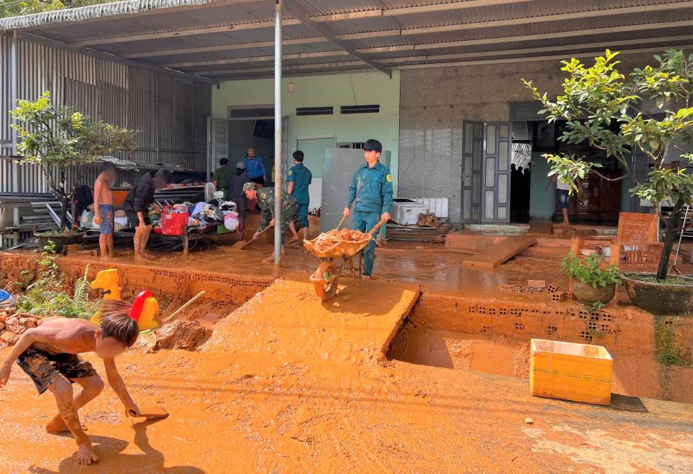 Các cán bộ, chiến sĩ, thanh niên bắt tay vào việc, hỗ trợ người dân khắc phục hậu quả trận lũ quét. Ảnh: Lam Hồng