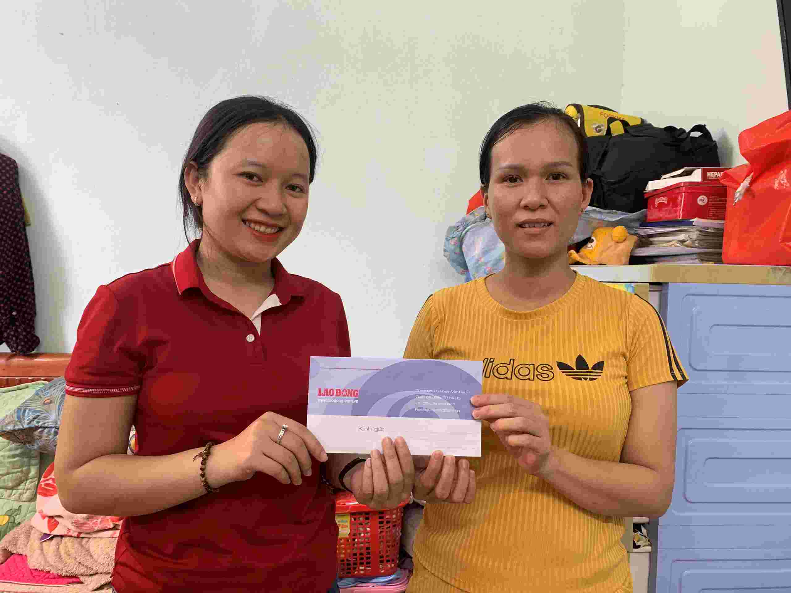 Phóng viên Nguyễn Linh (bên trái) thay mặt Quỹ Xã hội từ thiện Tấm lòng Vàng trao tận tay chị Võ Thị Mỹ Lệ số tiền 7.925.000 đồng. Ảnh: MỸ LINH