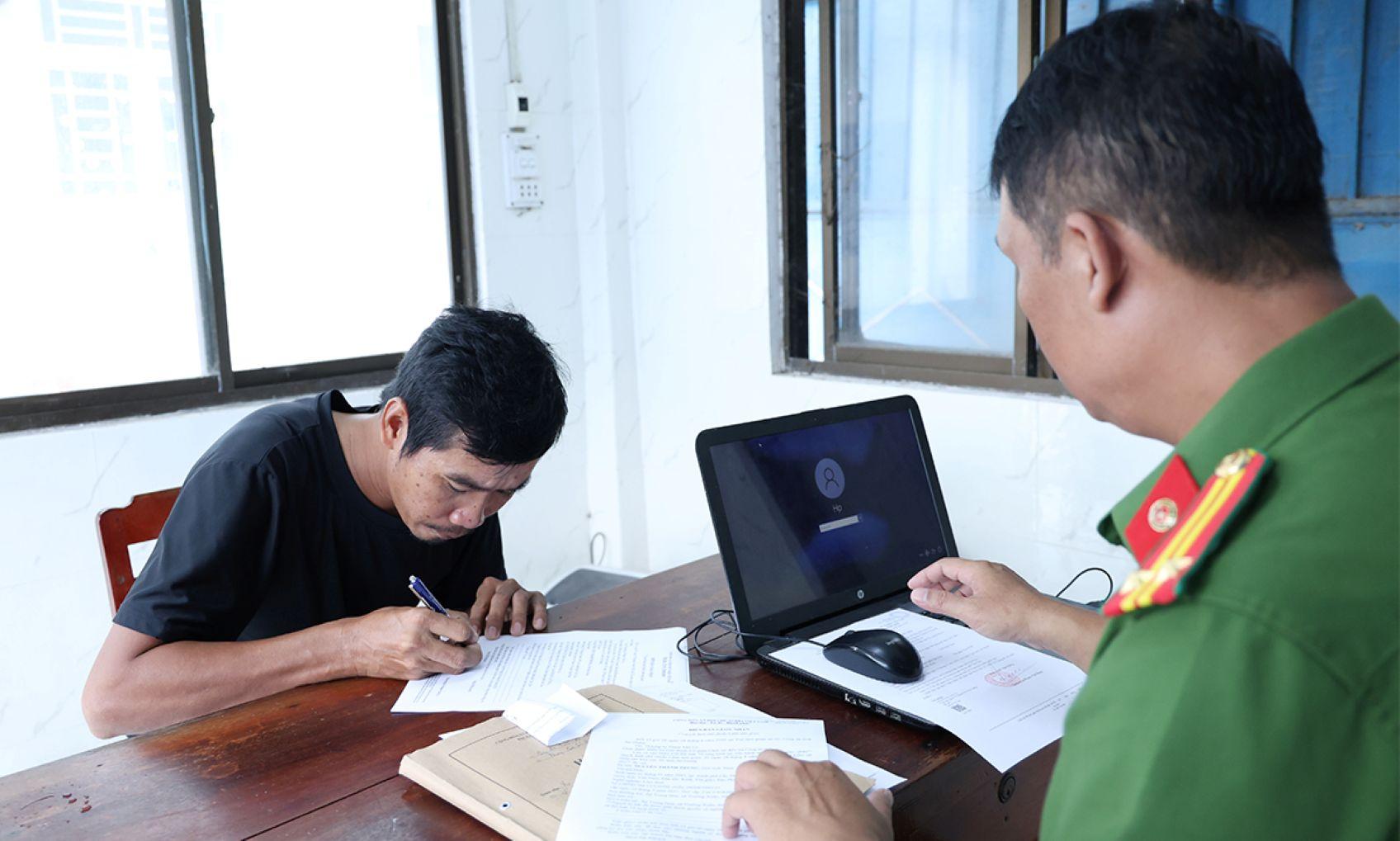 Bị can Nguyễn Thành Trung ký nhận các quyết định và lệnh tạm giam. ẢnhL Vũ Tiến