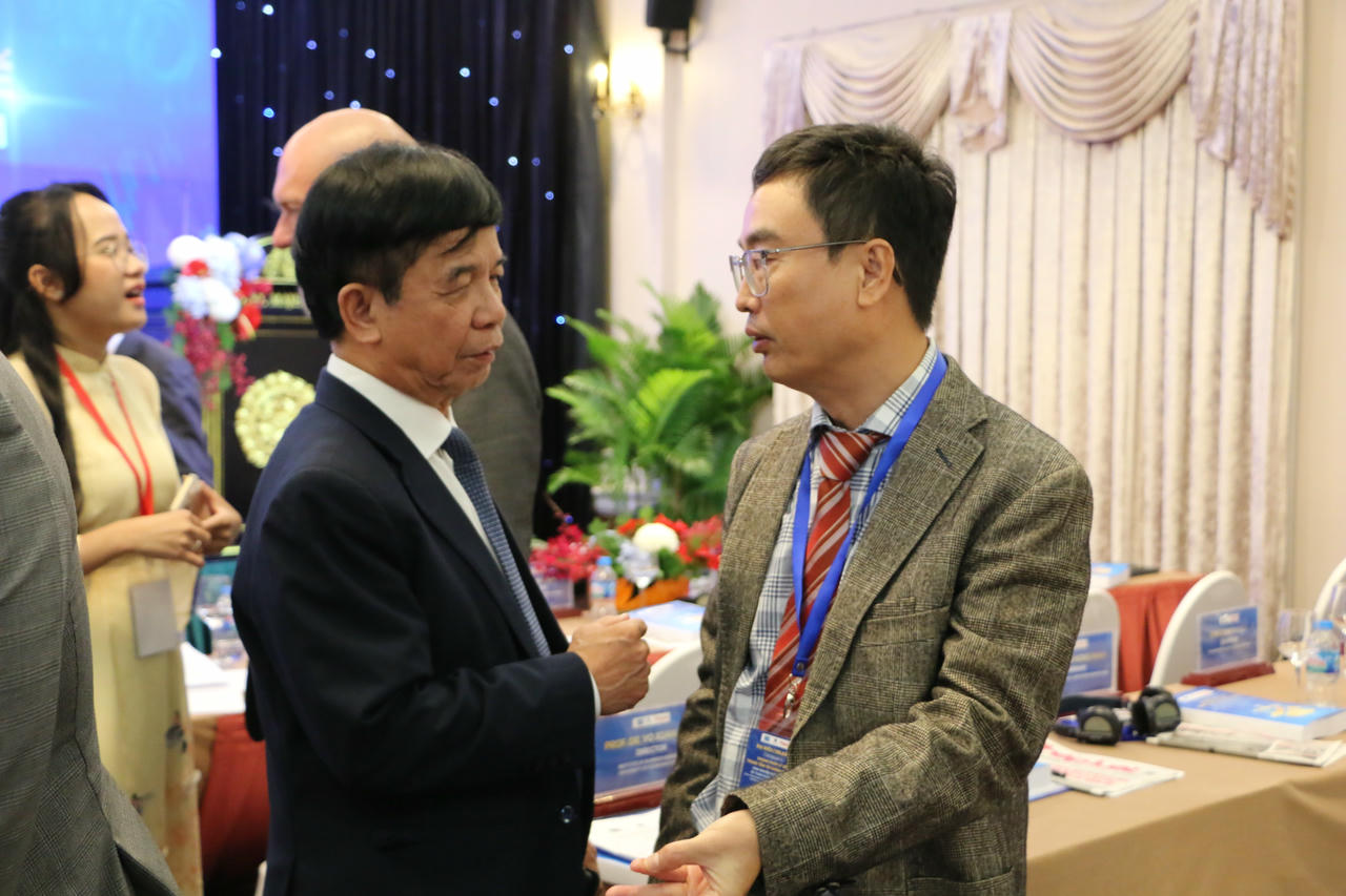 GS.TS Lê Hồng Hạnh trao đổi với GS.TS Võ Xuân Vinh bên lề hội thảo quốc tế về Khung pháp lý cho Trung tâm Tài chính quốc tế