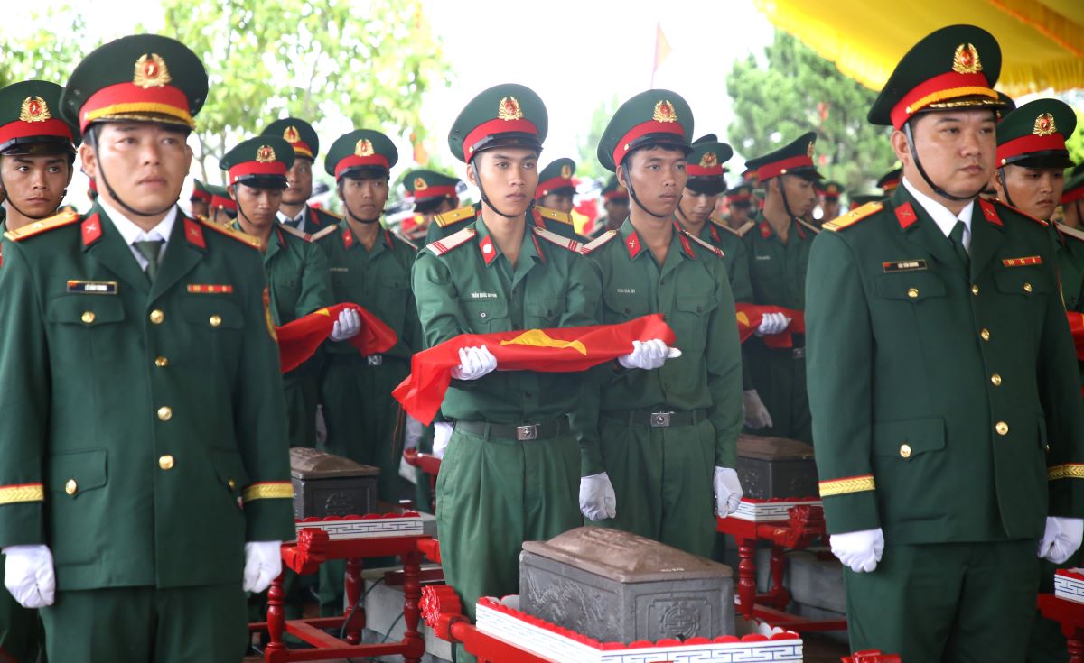 Thu Quốc kỳ, chuẩn bị cho lễ an táng các hài cốt liệt sĩ. Ảnh: Hưng Thơ