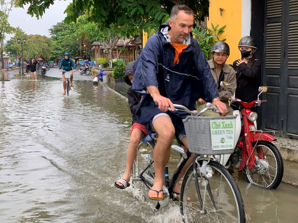 Du khách nước ngoài tỏ ra thích thú khi đạp xe qua những vùng ngập nước. Ảnh: Thanh Huyền