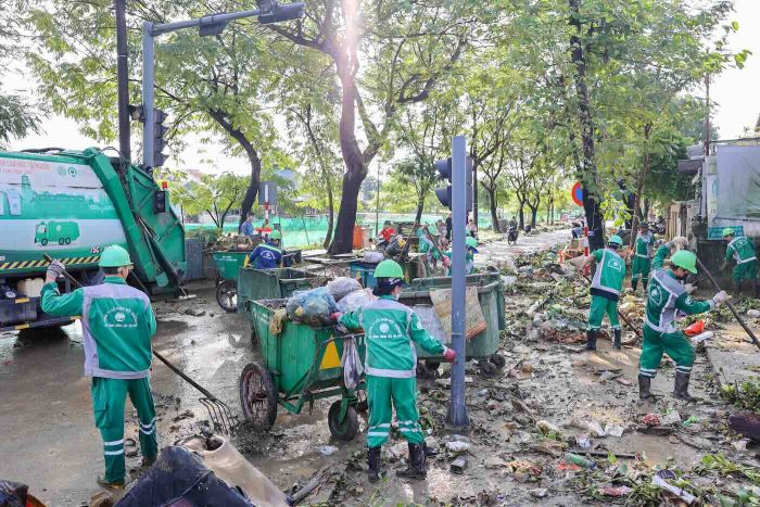 Công nhân môi trường vất vả dọn dẹp sau lũ. Ảnh: Phúc Đạt