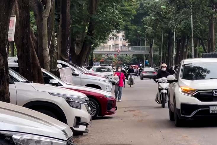 Người dân đi bộ dưới lòng đường do vỉa hè bị chiếm dụng. Ảnh: Tùng Giang