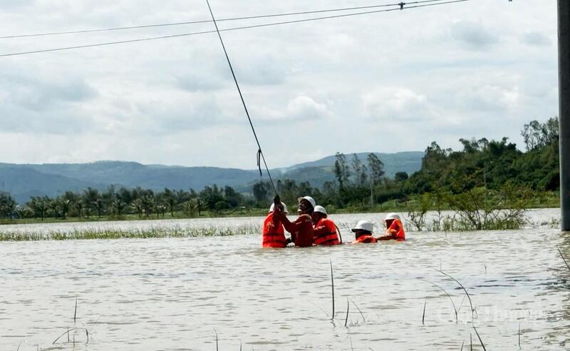 Không quản ngại gian khó, cán bộ Công ty Điện lực Đắk Lắk ngâm mình trong nước để khắc phục hậu quả do cơn bão số 13 gây nên. Ảnh: Hồng Hoa