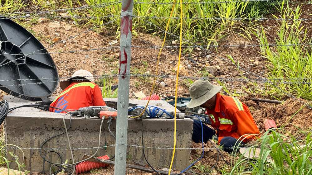 Công nhân thi công hệ thống cáp truyền dữ liệu cho camera. Ảnh: Duy Tuấn
