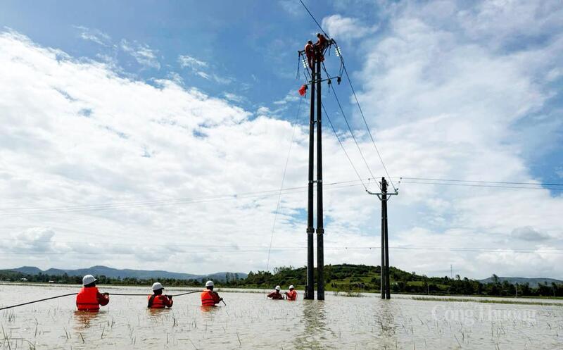 Cán bộ ngành điện ở Đắk Lắk ngâm mình trong nước để khắc phục sự cố đường dây hỏng do bão số 13 gây nên. Ảnh: Hồng Hoa
