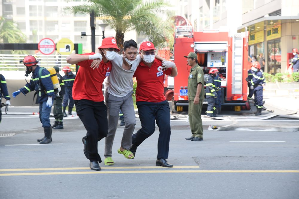 Cư dân được hướng dẫn thoát nạn ra khu vực an toàn trong tình huống giả định. Ảnh: Linh Trần