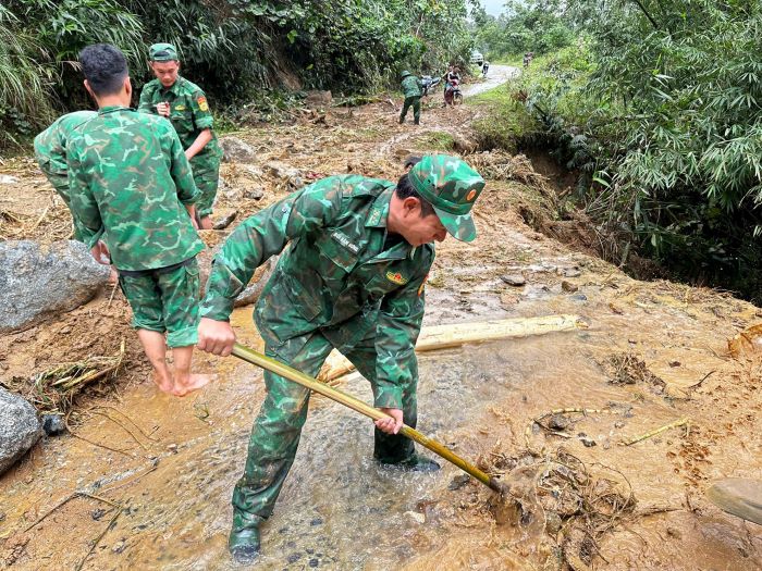 Khơi thông đoạn đường đầy bùn đất và đá tảng. Ảnh: H.Nguyên