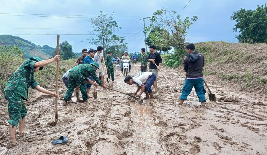 Đường ngập ngụa bùn đất, người dân và lực lượng biên phòng phối hợp khắc phục. Ảnh: H.Nguyên
