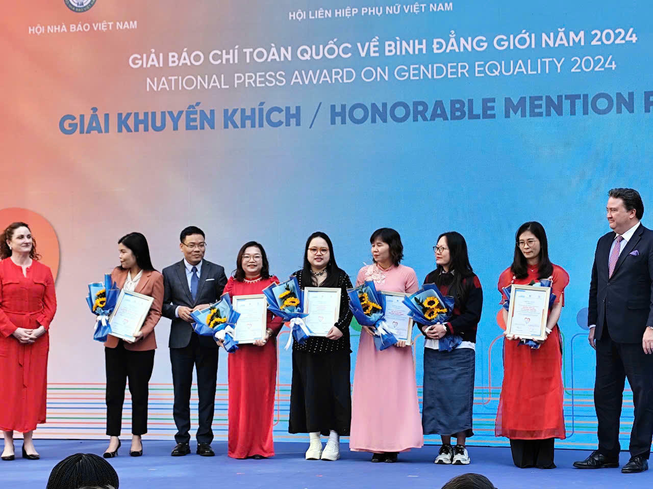 Phóng viên Đỗ Thùy Trang (người giữa hàng) thay mặt nhóm tác giả Báo Pháp luật Việt Nam nhận Giải Khuyến khích thể loại báo in của Giải Báo chí toàn quốc về Bình đẳng giới lần thứ I năm 2024. Ảnh X.H