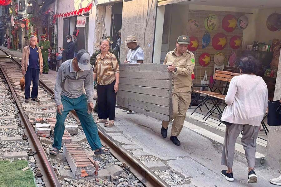 Lực lượng chức năng giải tỏa các hạng mục vi phạm an toàn hành lang đường sắt trên phố cà phê đường tàu. Ảnh: Tiến Ngô