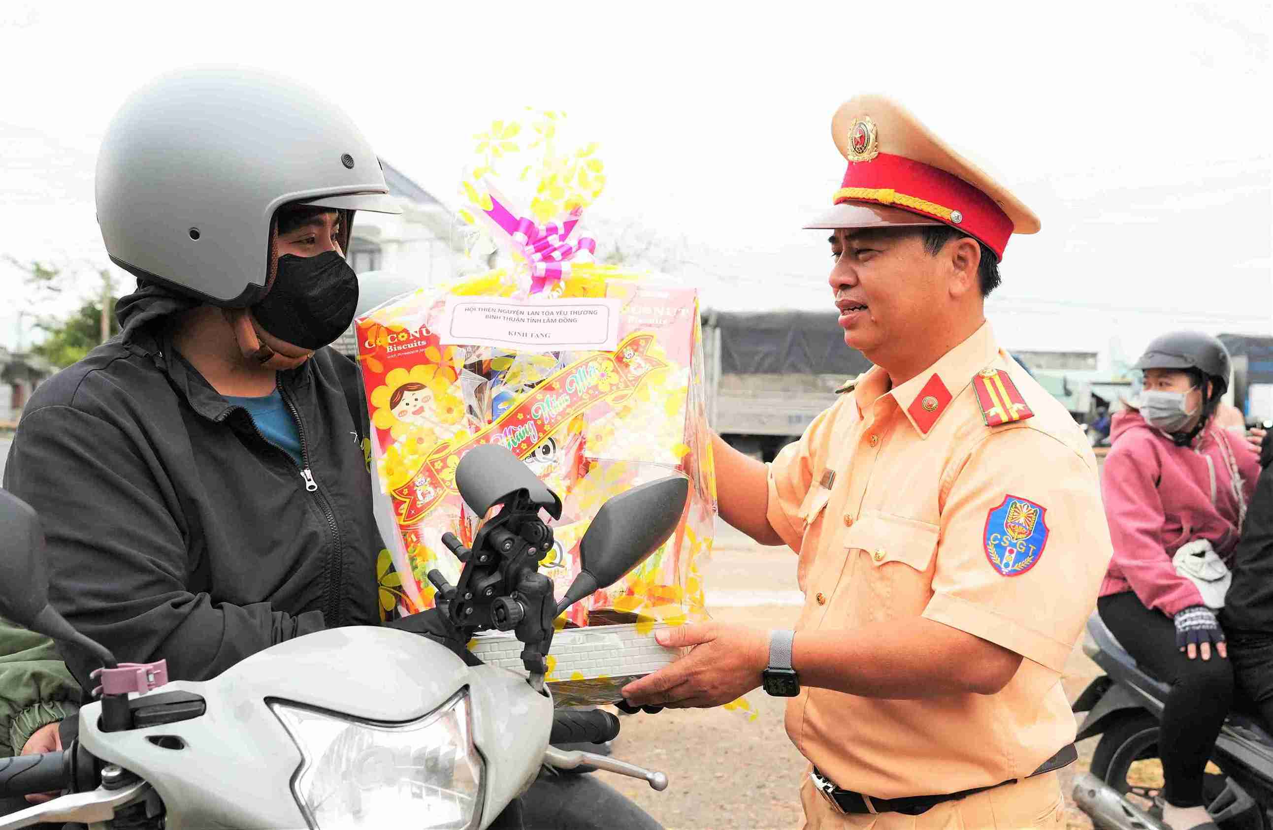 Đội Cảnh sát giao thông đường bộ số 3 Công an Lâm Đồng tặng quà cho người dân trên đường về quê ăn Tết. Ảnh: Hoàng Long