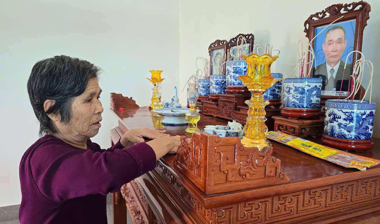 Bà Trịnh Thị Sợi đang lau dọn lại bàn thờ để chuẩn bị đón Tết. Ảnh: Diệu Anh