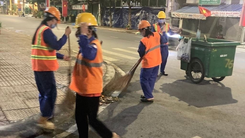 Công nhân vệ sinh môi trường thu gom rác trên tuyến phố trong đêm Giao thừa. Ảnh: Hoàng Lộc