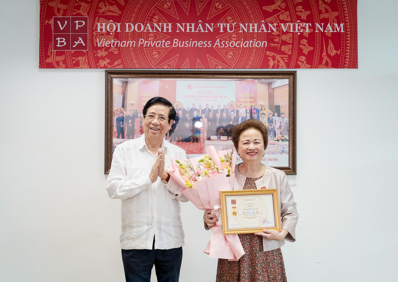 PGS.TS Nguyễn Trọng Điều, Chủ tịch Hội Doanh nhân Tư nhân Việt Nam, trao kỷ niệm chương cho bà Nguyễn Thị Nga.