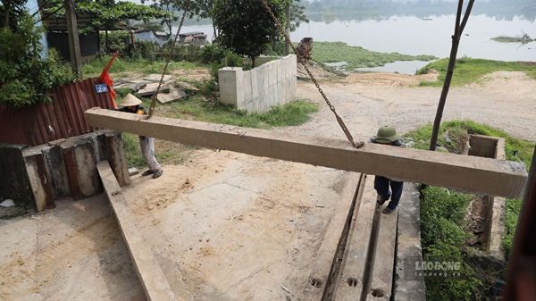 Các thành viên lực lượng xung kích giữ ổn định tấm phai trong quá trình thực hành đóng cửa khẩu đê. Ảnh: Trung Nguyên