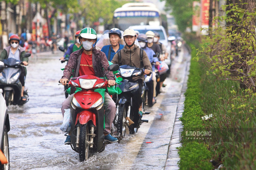 Trong giờ cao điểm buổi sáng, lượng phương tiện lưu thông trên Quốc lộ 32 đông, các phương tiện phải nối đuôi nhau di chuyển qua khu vực còn ngập.